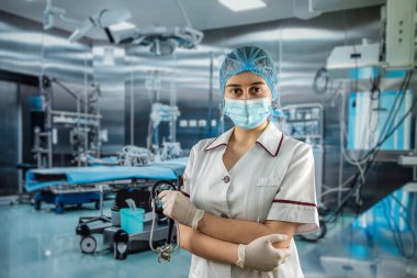 Genç, güzel bir doktor ya da asistanın portresi steteskoplu beyaz üniforma giyer. Modern ameliyathanede çalış.