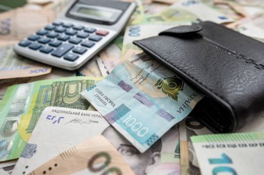 exchange of US dollars to Ukrainian hryvnias on the table with a calculator. Exchange rate concept