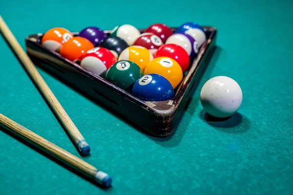 Billiard balls on the table and the player\'s hands are preparing to strike in the start mode. Indoor sports concept