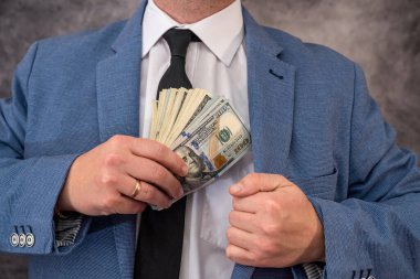 Takım elbiseli bir işadamı ya da memur cebine 100 dolarlık banknotlar şeklinde rüşvet koyuyor. Yetkililer arasında yolsuzluk ve rüşvet kavramı
