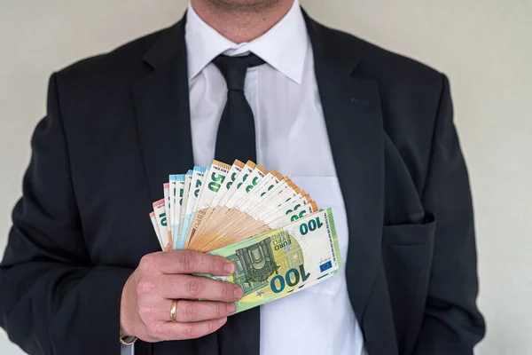 man in suit with good taste holds euro banknotes for big purchase. Big purchase concept