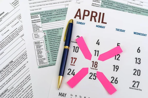tax forms and next to the calendar with a date mark when you need to file a return. The concept of an important date for taxpayers