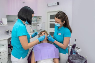 beautiful young woman came to the dentist to the woman's own dentist to check the teeth for caries. The concept of checking teeth in women