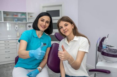 team of dentists and patient happily showing thumbs up. Concept of happy dentists