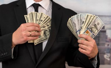 a university lecturer in a suit takes bribes in dollars and hides money in his pocket. The concept of large bribes in educational institutions