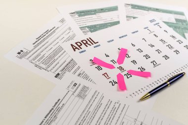 tax forms and next to the calendar with a date mark when you need to file a return. The concept of an important date for taxpayers