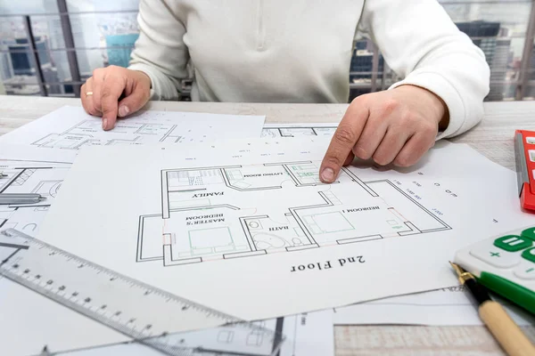 a professional architect makes a custom sketch of an apartment building in a large complex. Male hands draw sketches of drawings at the table