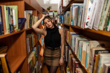 Güzel esmer kadın kitap okumak için boş zamanlarında gelir. Kütüphane konsepti. Bilgi kavramı