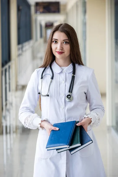 young experienced pediatrician doctor with patient log standing in hospital. Concept of medicine. The pediatrician is a woman. Portrait of a woman