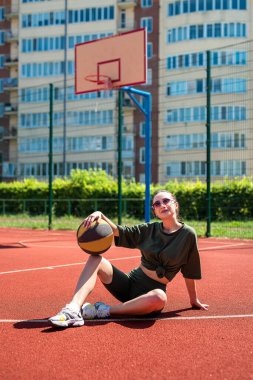Sportif figürlü atletik seksi kız sahada basketbol oynuyor. Basketbol oyunu konsepti