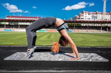 Stadyumda esneme hareketleri yapan bir kadın. fitness konsepti