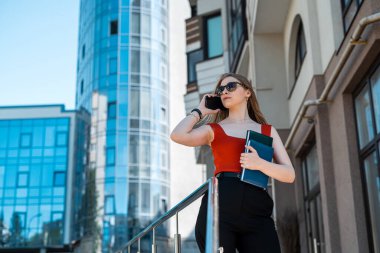Business confident successful young professional businesswoman in suit standing near office building with arms crossed. Business concept