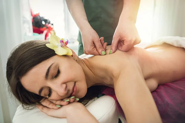 Young woman lying on table and receive relax massage on spa. Spine health concept