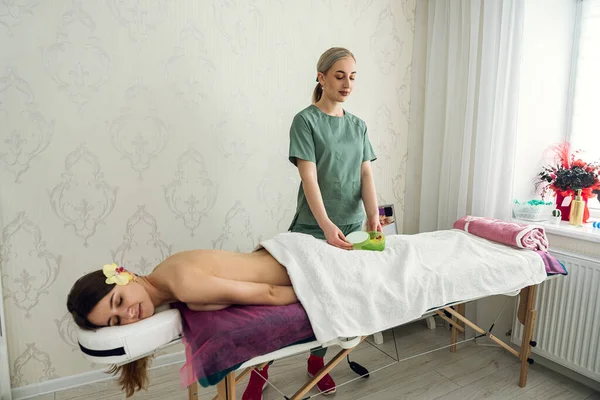 Happy Female Cosmetologist Standing Her Woman Client Lying Spa Table — Stok fotoğraf