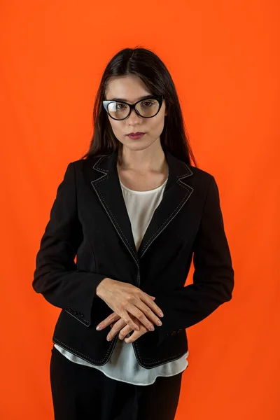 Smiling female teacher in modest clothes with folded hands on her chest isolated on a plain background. portrait of a female teacher. the school is a paradise for schoolchildren