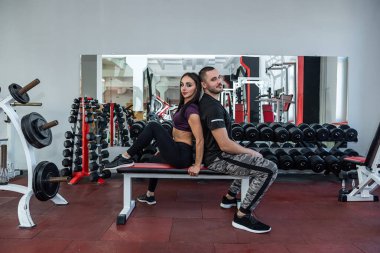 Mutlu, yorgun müşteri, gelecek vaat eden egzersizleri ve fiziki durumu için spor eğitmeni kocasına minnettar. Koçunun kocasına minnettar olan bir müşteri konsepti.