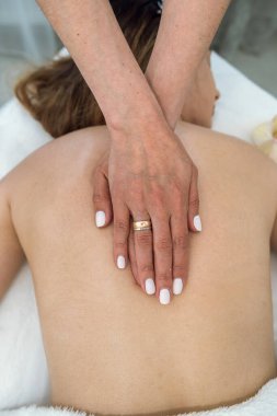 young woman has problems with her spine and is receiving treatment at a spa