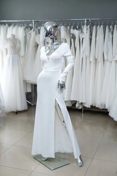 white wedding dresses on mannequin and away hanging on hangers in shop showroom