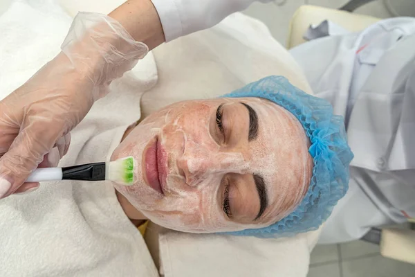 professional beautician performs ultrasonic cleaning of the skin of the face with the help of a device. Cosmetic procedure in the salon of the beauty clinic. The concept of machine cosmetology.