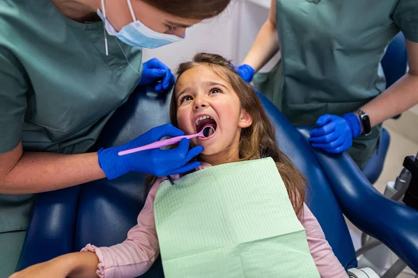 Κοριτσάκι Που Κάθεται Οδοντιατρική Καρέκλα Και Δύο Γυναίκες Οδοντίατροι Που — Φωτογραφία Αρχείου