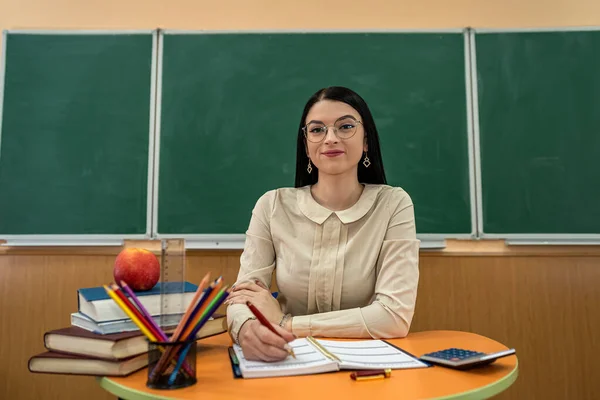 Beautiful Teacher Glasses Sits Desk Book Pencil Notepad Apple Blackboard — Stock Photo, Image