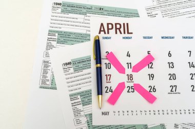 tax forms and next to the calendar with a date mark when you need to file a return. The concept of an important date for taxpayers