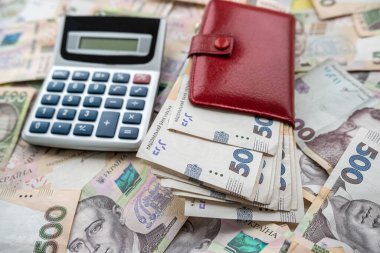 financial concept uah ukraine money with calculator and purse on desk. investment, currency background