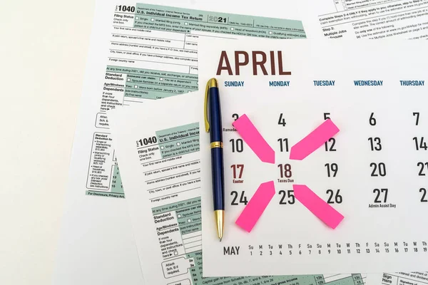 tax forms and next to the calendar with a date mark when you need to file a return. The concept of an important date for taxpayers