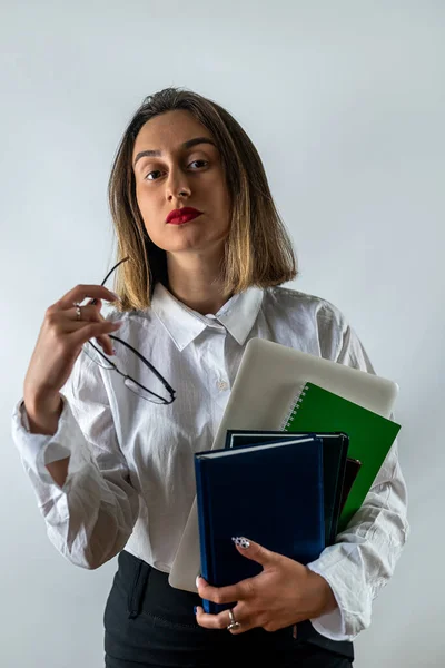 business woman in business style with books in hands smiling on isolated white studio background. studio shooting. business woman.