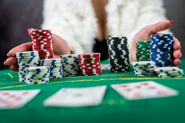 young woman in a black dress wins a game of blackjack and is happy with all the chips after playing poker. gambling concept. all in