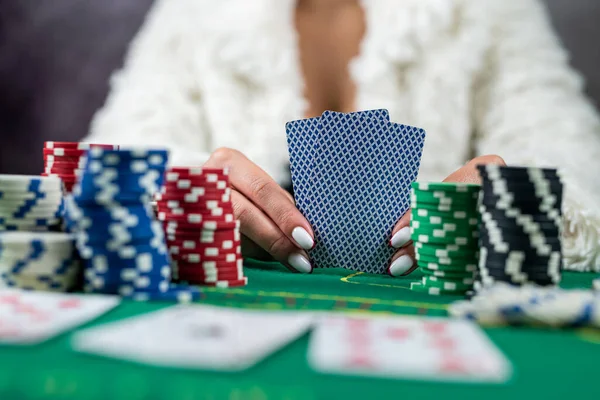 beautiful woman with poker cards is playing low in poker. gambling in the casino. woman in casino
