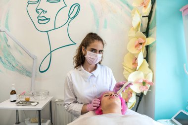 Profesyonel bir kozmetikçi müşterinin cildini sorun var mı diye kontrol eder. Kozmetoloji cilt testi cihazı. Güzellik prosedürleri