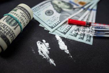 Para ve uyuşturucu, siyah cam bir masanın üzerinde şırıngaların yanında. Para şırıngası ve uyuşturucu. Kanun ihlali