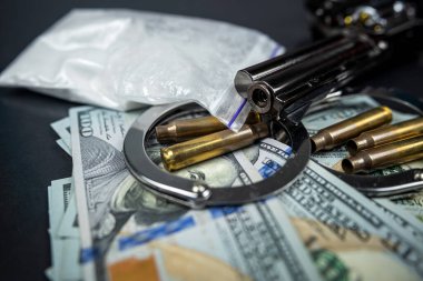 Uyuşturucu kaçakçılığı, kaçakçılık ve kelepçe silah parası ve siyah arka planda kokain torbaları. Yasadışı maddeler ve tutuklama