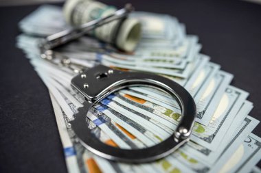 Banknotlar para ve kelepçe siyah arka planda izole. Yolsuzluk ya da dolandırıcılık için karanlık bir imaj. para aklama kavramı