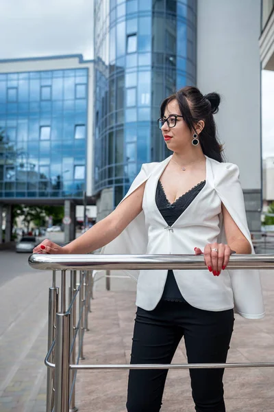 business lady talking on the phone and looking at the clock to be in time to the office. The concept of a girl from the office