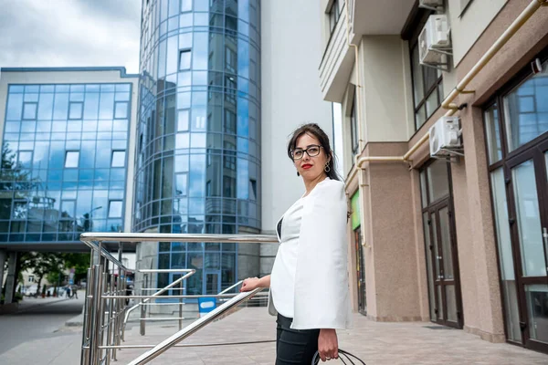 business lady talking on the phone and looking at the clock to be in time to the office. The concept of a girl from the office