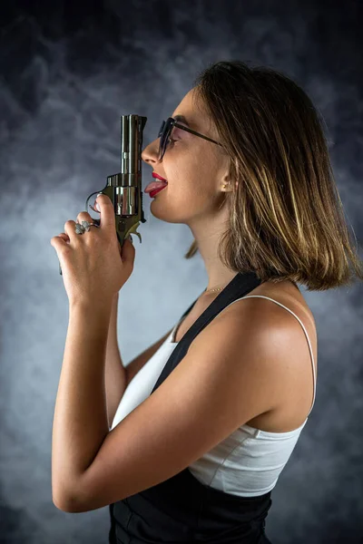 Genç Güzel Seksi Esmer Kadın Elinde Silahla Arka Planda Poz — Stok fotoğraf