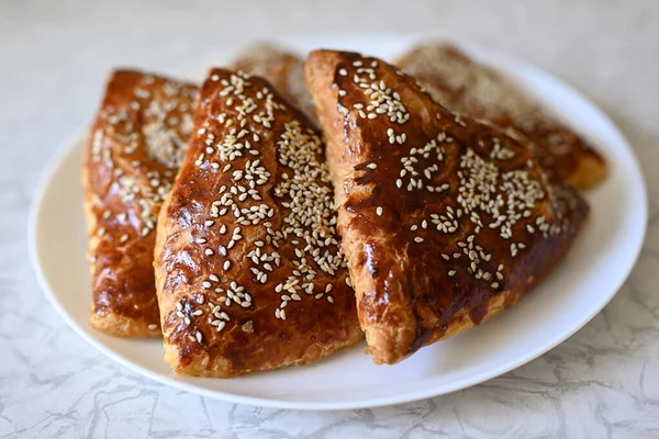 Masada gözlüklü üzgün kedi oturuyor. Masanın üzerinde boş bir defter ve bir kalem var. İnsan olarak hayvan kavramı. Kedi masada oturuyor..