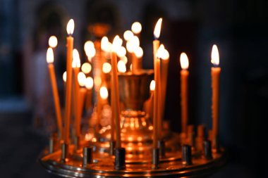 Arka plan bulanık. Hıristiyan kilisesinde mum yakmak.