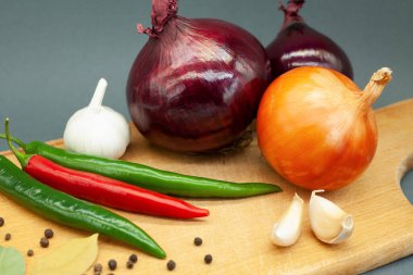 Tahta üzerinde sebze kompozisyonu. Tahtada soğan, sarımsak ve biber..
