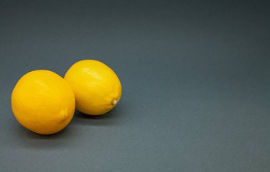 Gri arka planda iki limon. Yılın renkleri. Metin için boşluk.