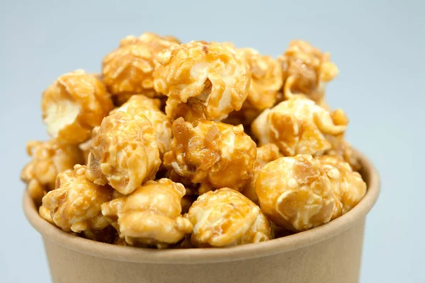 Kağıt bardakta karamelize patlamış mısır. Yakın plan. Eko konsepti, el işi kağıt bardak. Makro fotoğrafçılık.