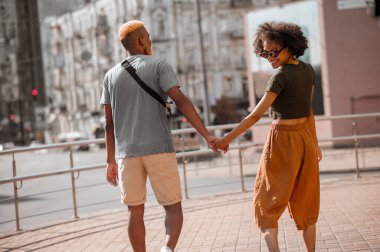 Sokakta mutlu, esmer tenli bir çift heyecanlı görünüyor.