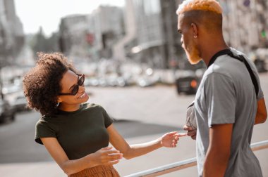 Genç bir adam ve bir kadın sokakta günün tadını çıkarıyorlar.