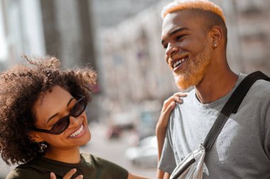 Mutlu bir çift sokakta selfie çekiyor ve mutlu görünüyorlar.