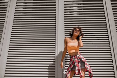 Kulaklık takmış, müzik dinleyen hoş bir genç kadın.