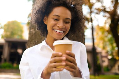 Parkta vakit geçiren ve mutlu görünen genç bir kadın.