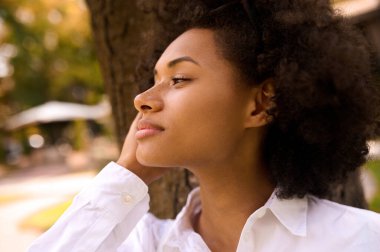 Parkta rahat ve mutlu vakit geçiren bir mulatta.