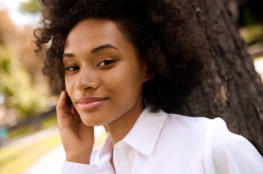 Parkta rahat ve mutlu vakit geçiren bir mulatta.